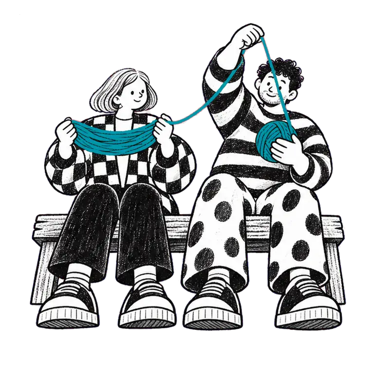 Two people sit on a bench; one holds a skein of yarn steady while the other winds it into a ball, both smiling.