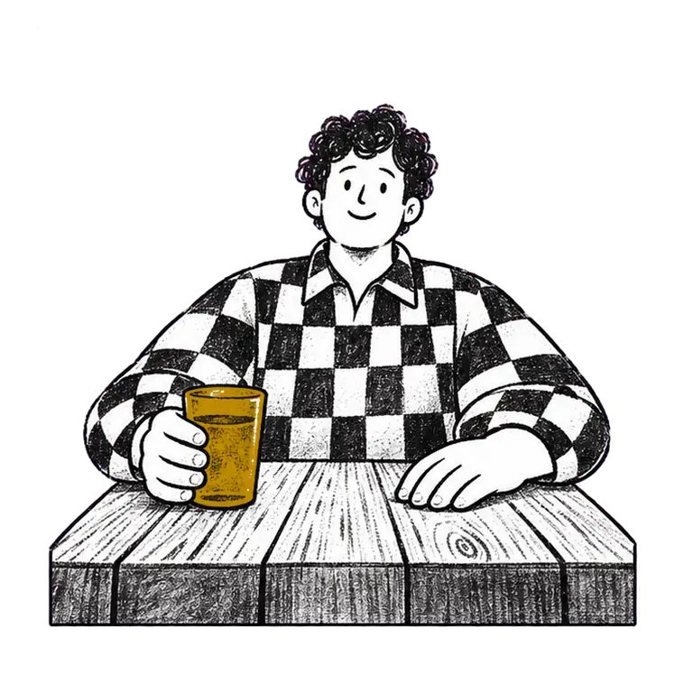 A man in a checked shirt at a wooden table lifts a glass of water, drinks, and holds it out toward the viewer.